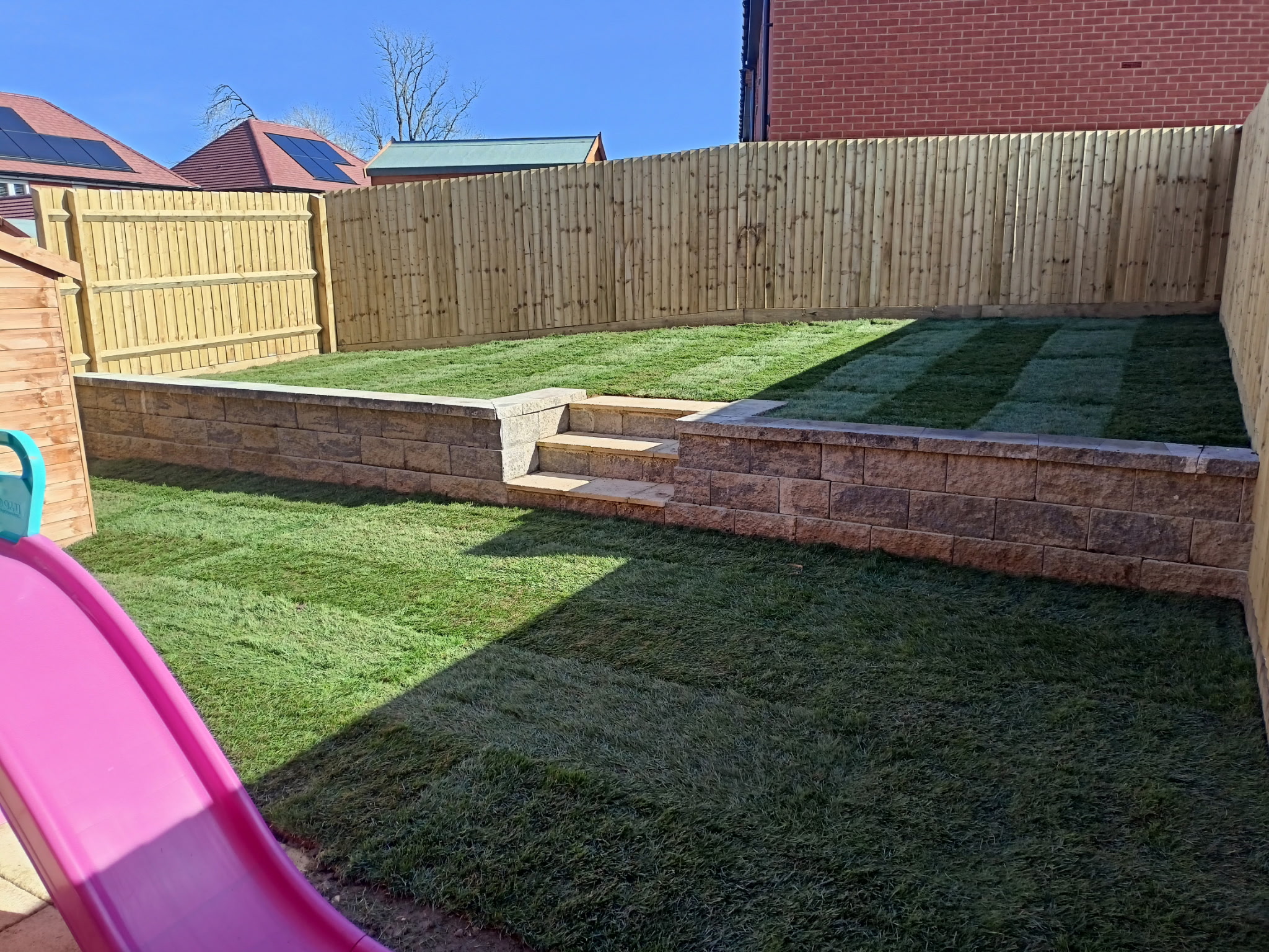 Garden with raised stone wall and lawn