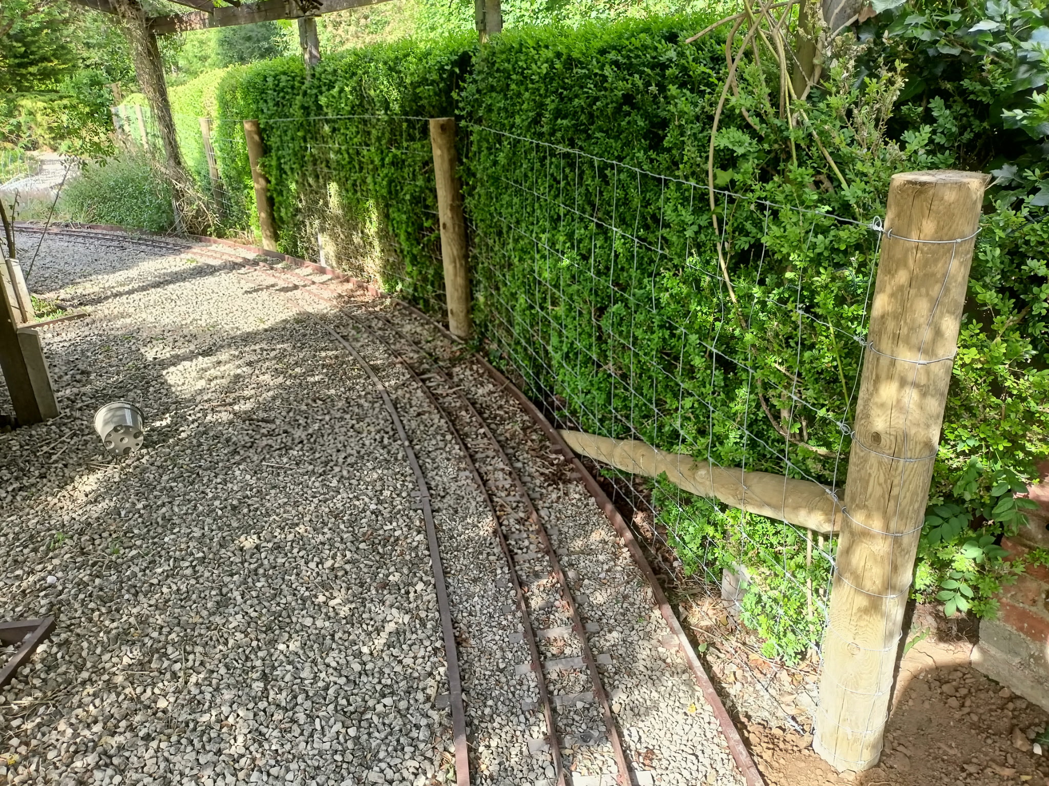 Gravel area with pergola and hedging